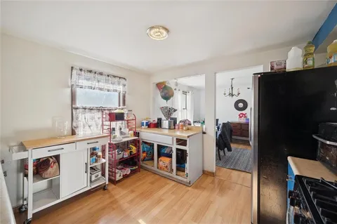 a view of kitchen with stainless steel appliances white cabinets and wooden floor