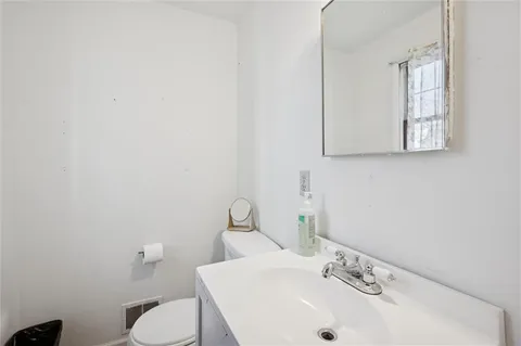 a bathroom with a sink mirror and toilet