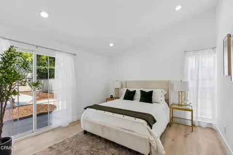 a bedroom with a large bed and a potted plant