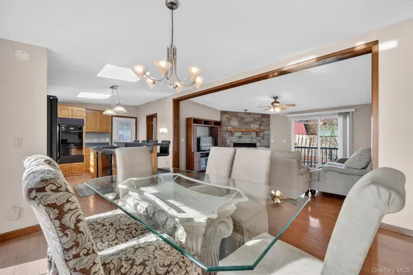 a living room with furniture dining table a flat screen tv and a chandelier