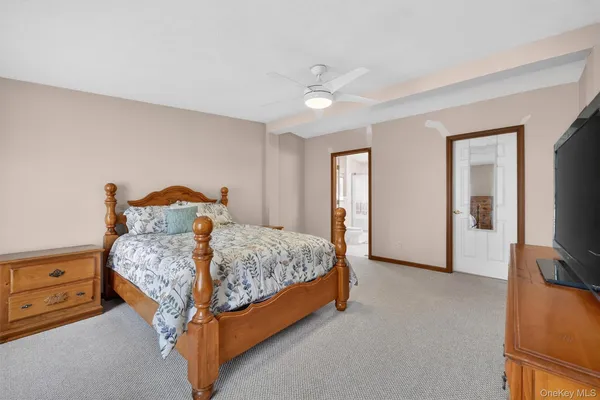 a bedroom with a bed and a flat tv screen on dresser