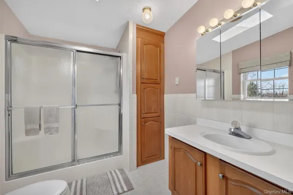 a bathroom with a shower sink and mirror