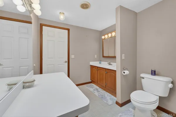 a spacious bathroom with a toilet sink and mirror