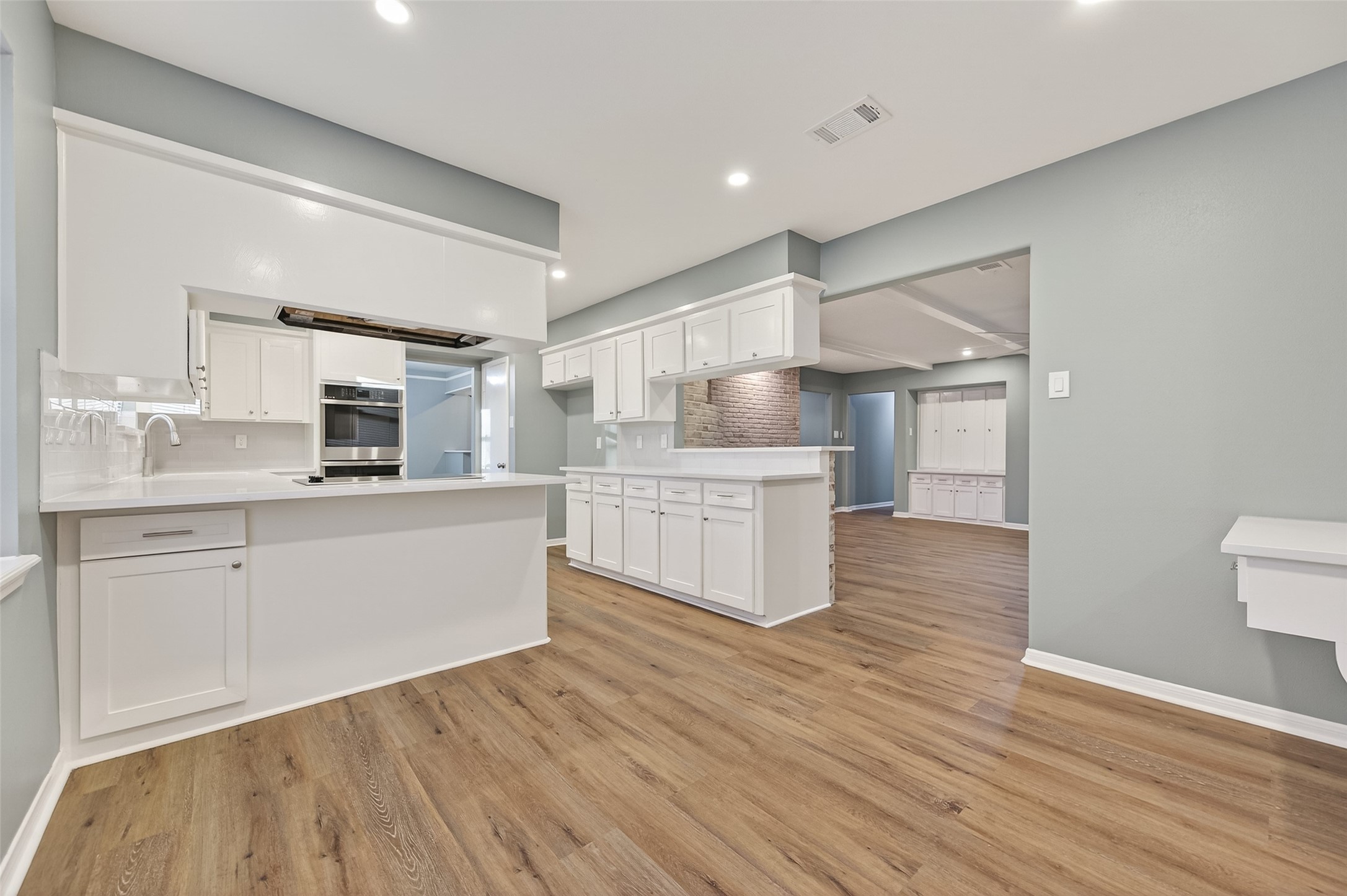 902 Kingsbridge Road Houston, TX 77073 - Photo 17 of 43 Its open-concept layout includes a large central island with a breakfast bar, all tied together by beautiful wood-look flooring.