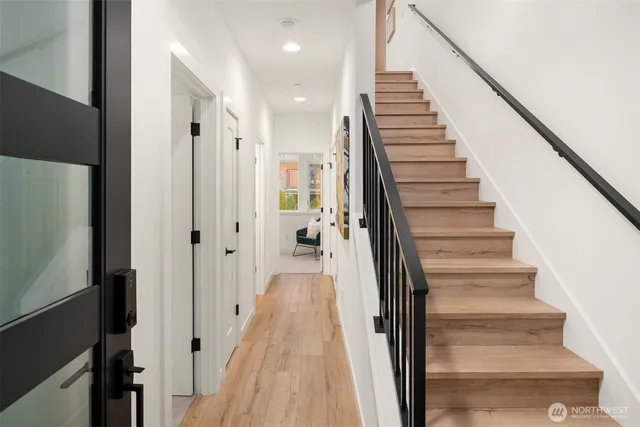 a view of a hallway with wooden floor and stairs