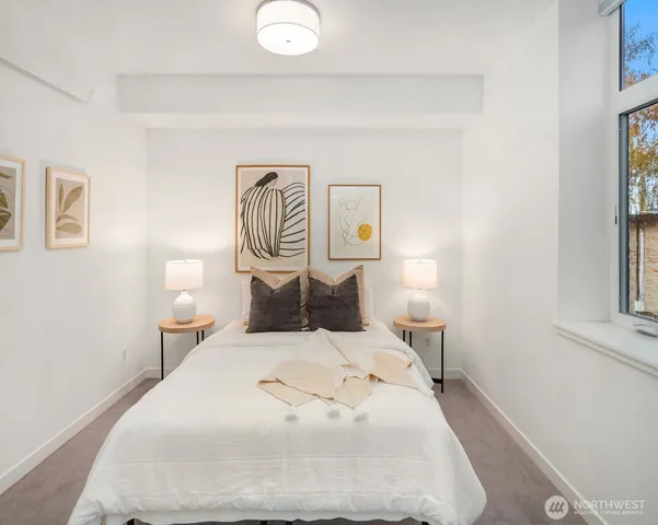 a bedroom with a bed and painting on the wall