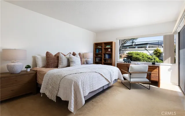 a bedroom with a bed and large windows