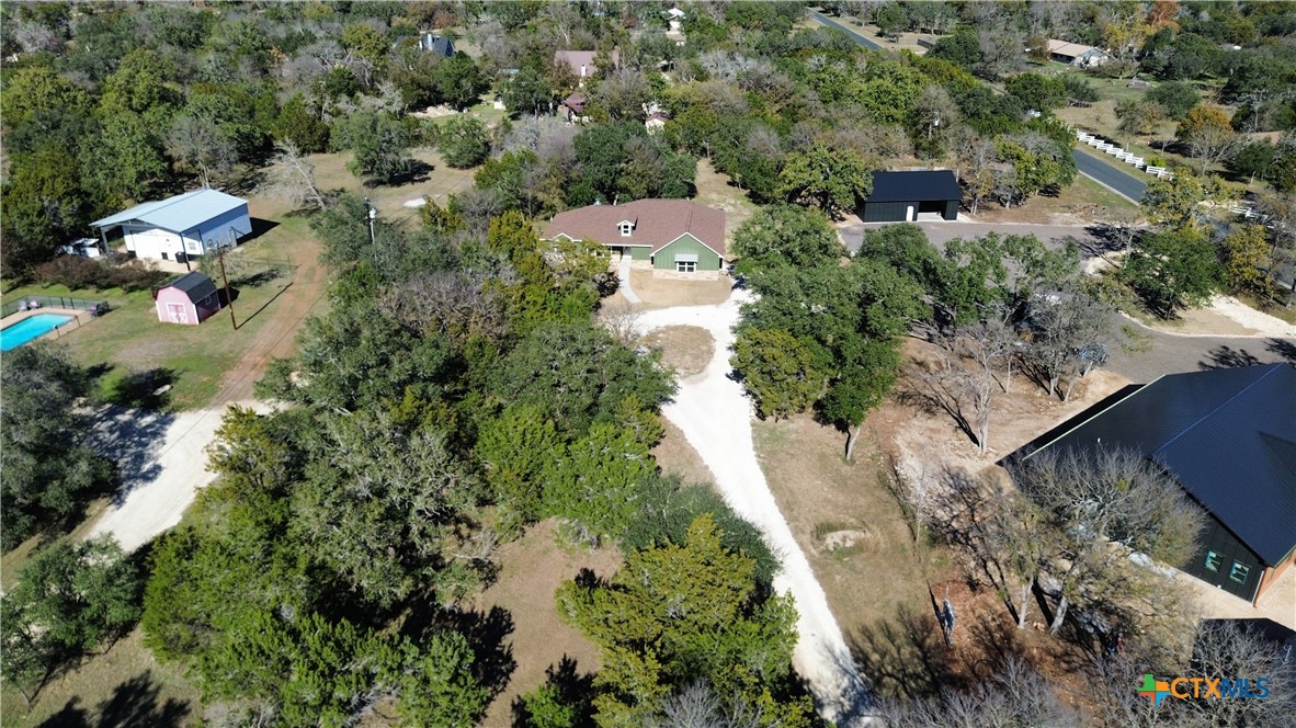 an aerial view of residential house with outdoor space and trees all around