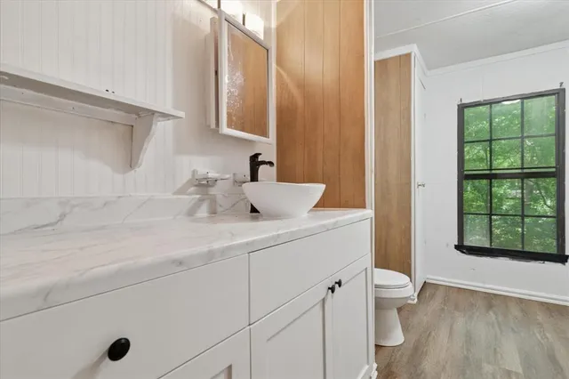 a bathroom with a sink a toilet and a window
