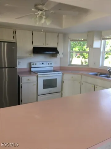 a kitchen with stainless steel appliances granite countertop a sink a stove and refrigerator