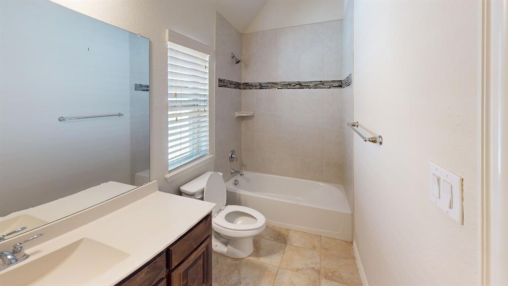 14712 Spitfire Trail Fort Worth, TX 76262 - Photo 12 of 25 Bathroom featuring a single vanity with dark wood cabinetry, an integrated sink, and a large wall-mounted mirror