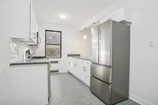 a kitchen with stainless steel appliances a refrigerator sink and cabinets