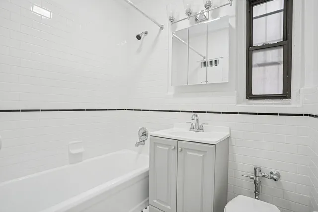 a bathroom with a sink and mirror with bathtub