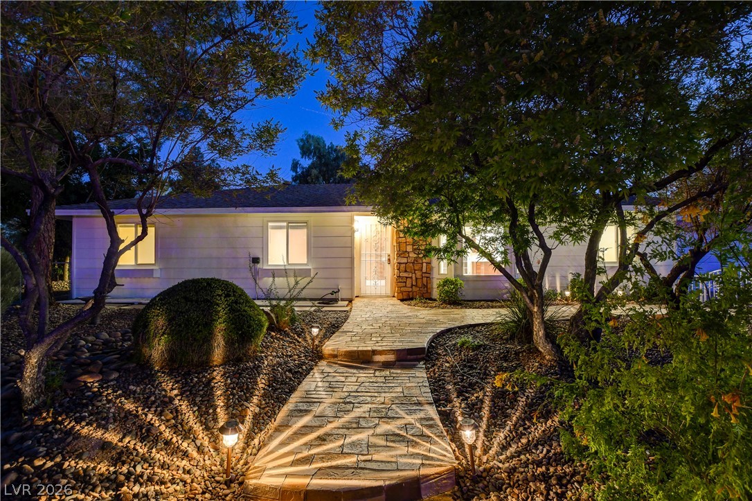 7631 Bermuda Road Las Vegas, NV 89123 - Photo 1 of 64 A welcoming stone pathway leads to this charming home, illuminated by soft landscape lighting.