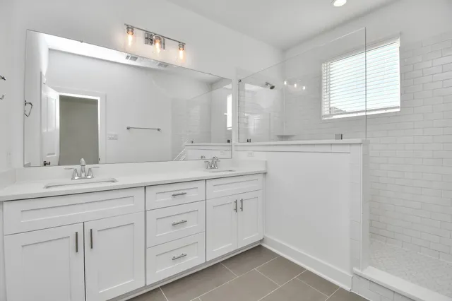 a bathroom with a granite countertop sink double and mirror
