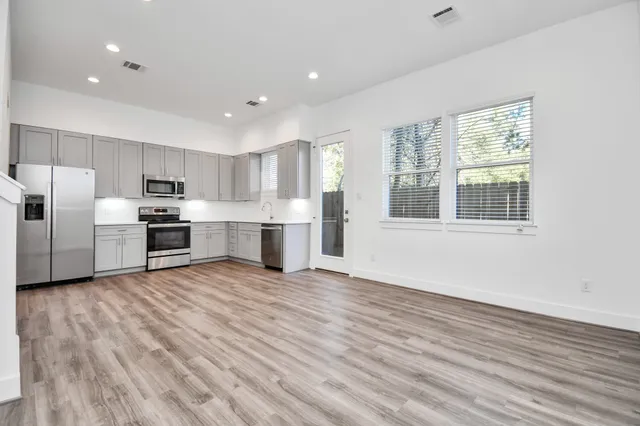 a view of kitchen with stainless steel appliances refrigerator oven and cabinets