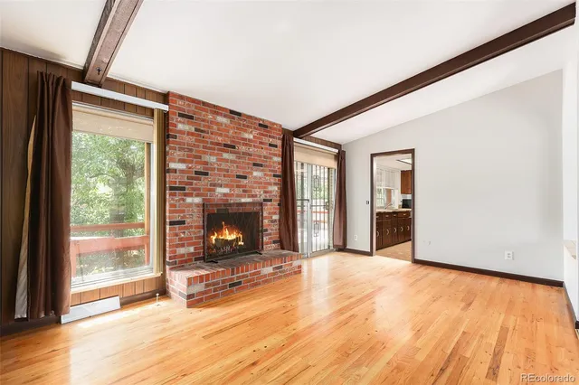 a view of an empty room with window and fire place