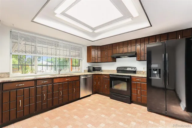 a kitchen with stainless steel appliances granite countertop a stove a sink dishwasher a refrigerator and a microwave oven with cabinets