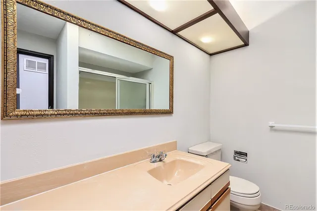 a bathroom with a toilet a sink and mirror