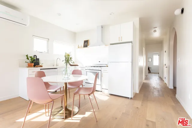 a kitchen with stainless steel appliances a refrigerator and a dining table