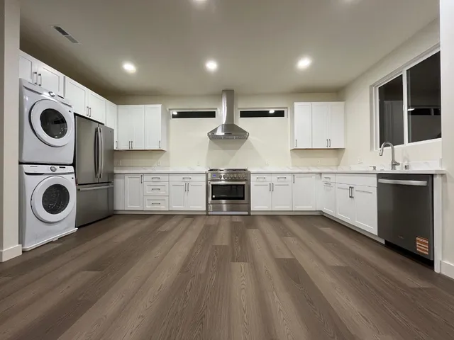 a kitchen with stainless steel appliances granite countertop a refrigerator and a stove top oven