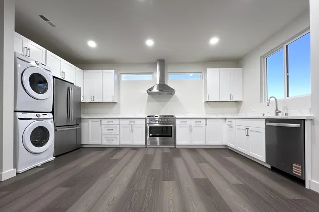 a kitchen with wooden floors and white cabinets