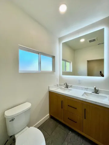 a bathroom with a toilet sink and mirror