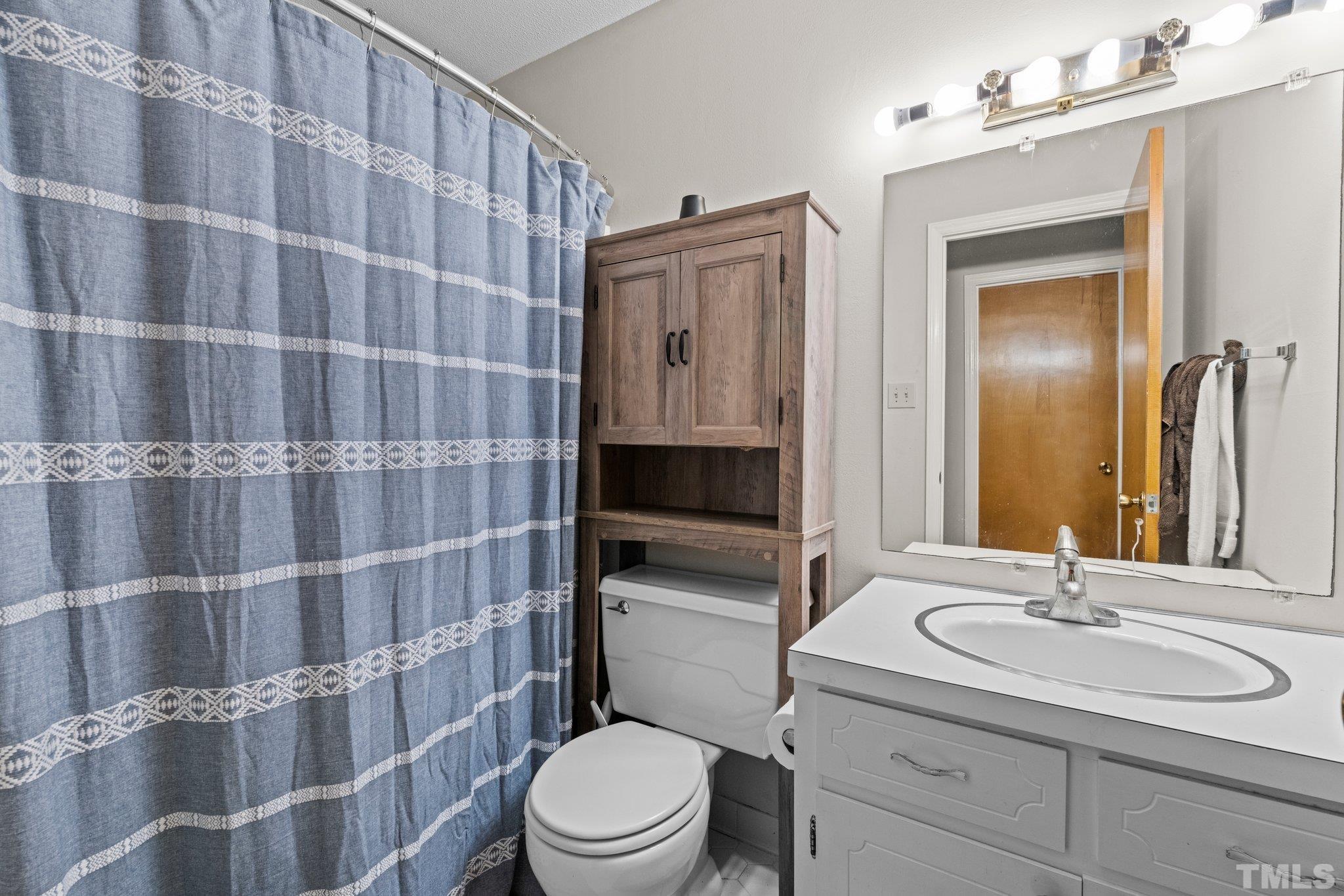 12233 Creedmoor Road Raleigh, NC 27613 - Photo 15 of 57 a bathroom with a sink a toilet and shower