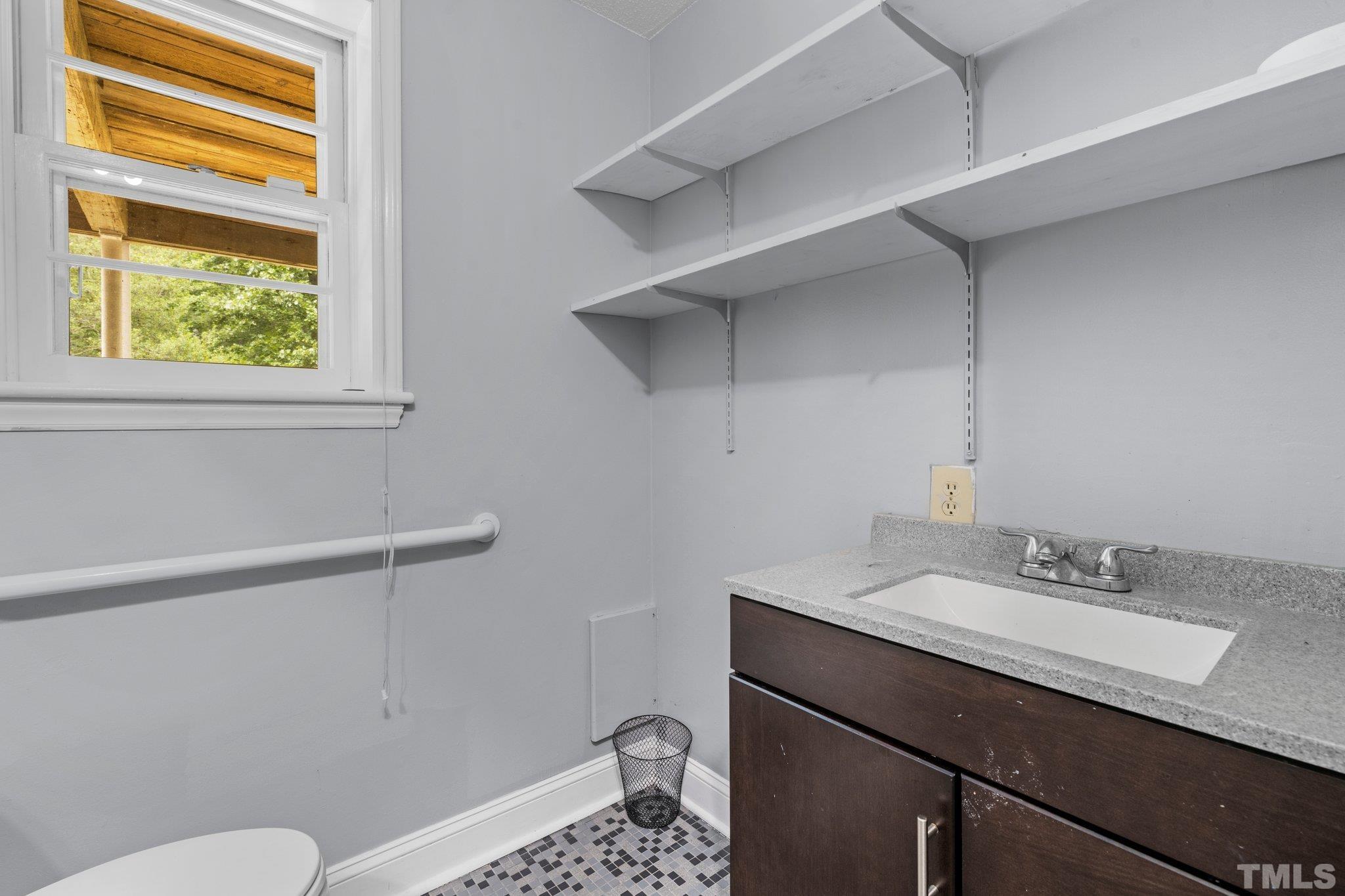 12233 Creedmoor Road Raleigh, NC 27613 - Photo 21 of 57 a bathroom with a sink a toilet a vanity and mirror
