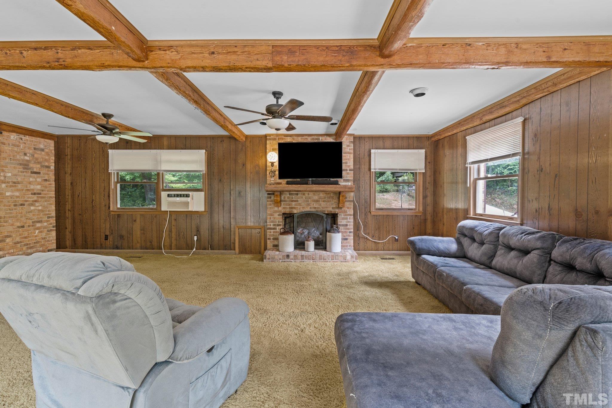 12233 Creedmoor Road Raleigh, NC 27613 - Photo 25 of 57 a living room with furniture a fireplace and a flat screen tv
