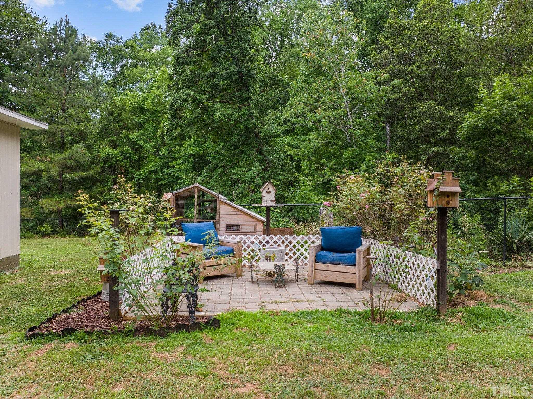 12233 Creedmoor Road Raleigh, NC 27613 - Photo 34 of 57 a view of a chair and table in the garden