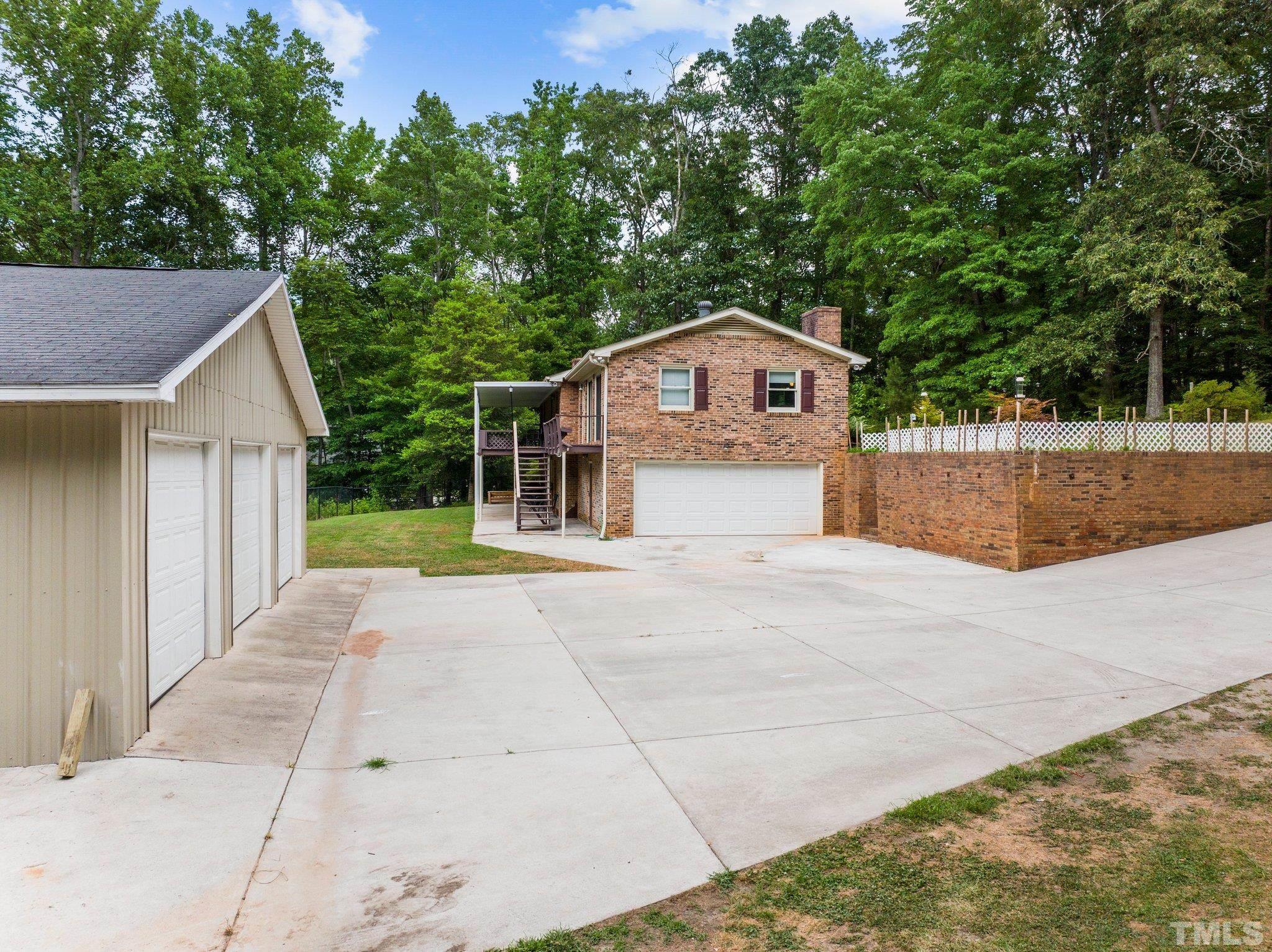 12233 Creedmoor Road Raleigh, NC 27613 - Photo 42 of 57 a view of a house with a yard and large trees
