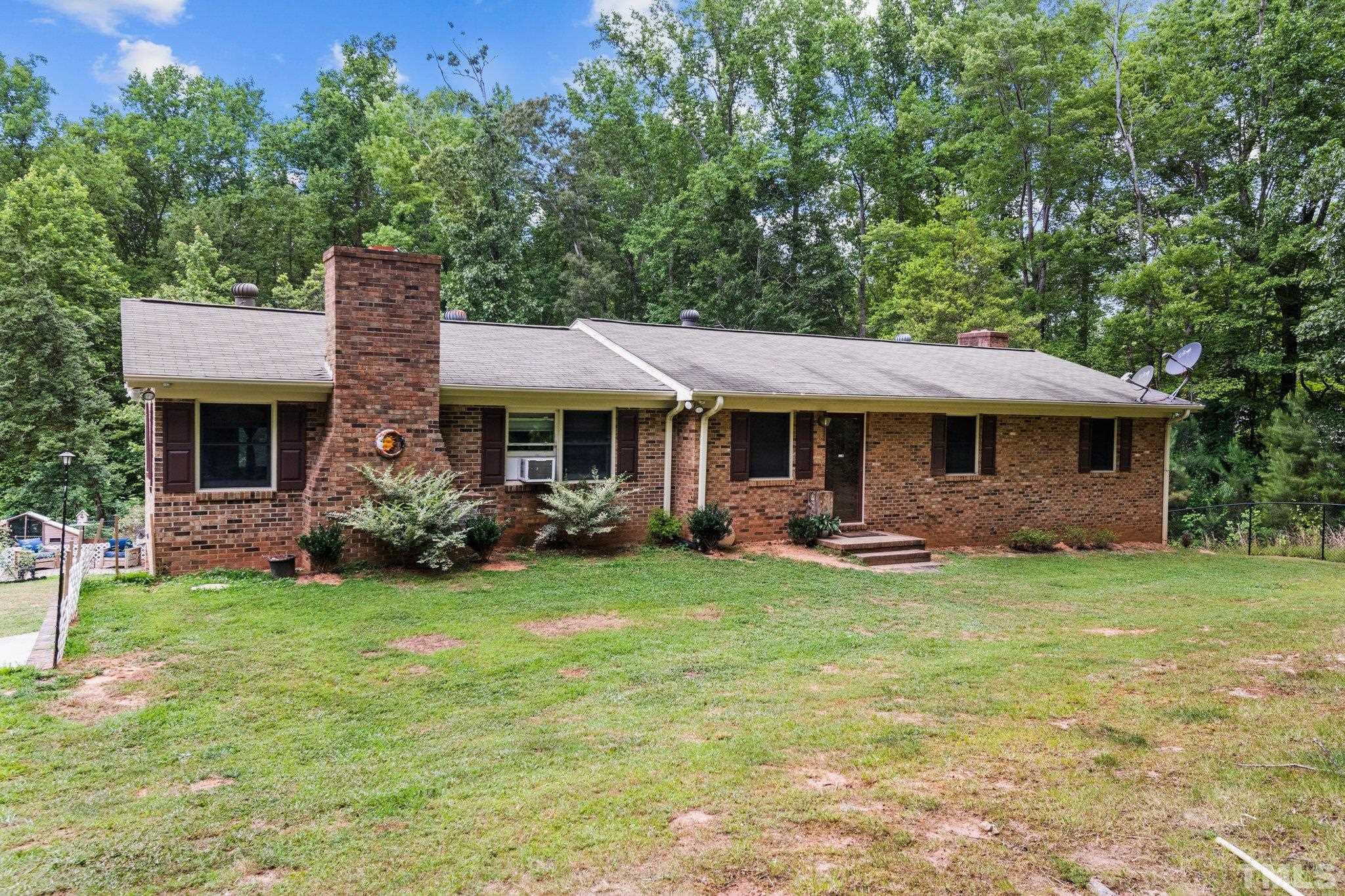 12233 Creedmoor Road Raleigh, NC 27613 - Photo 50 of 57 a front view of a house with a garden