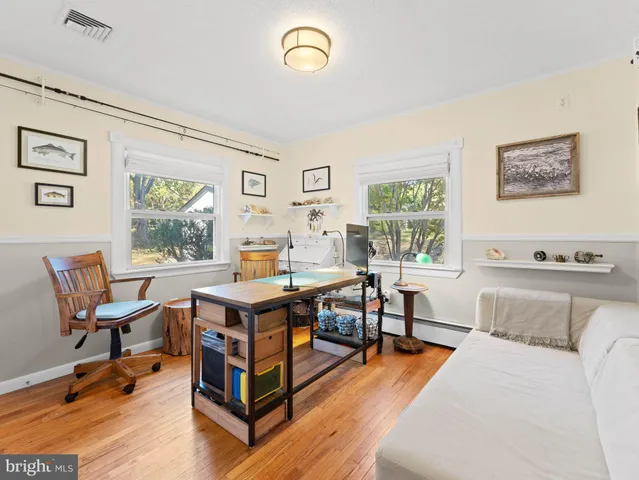 a view of an empty room with wooden floor and stairs