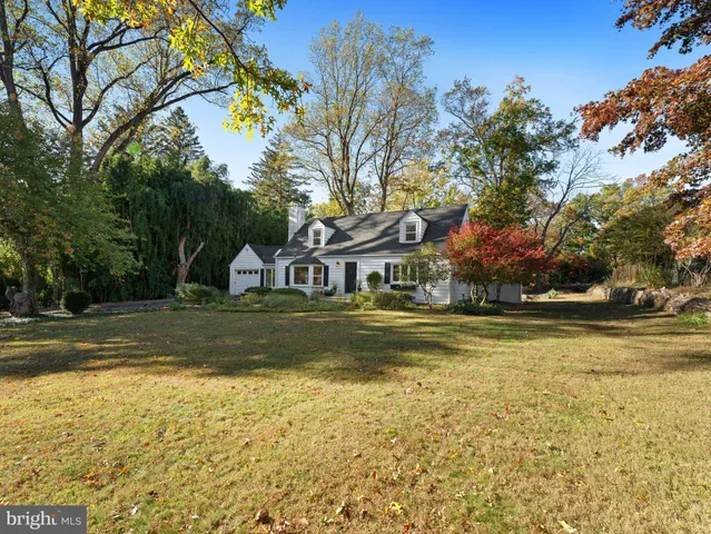 a view of swimming pool with lawn chairs and plants