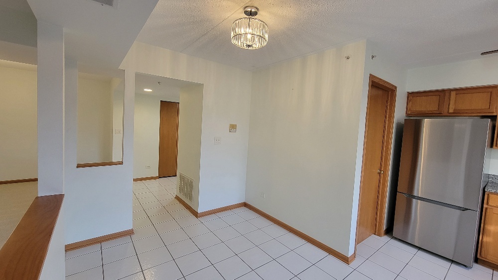 18100 Rita Road, Unit 2D Tinley Park, IL 60477 - Photo 17 of 28 a view of a refrigerator in kitchen and an empty room