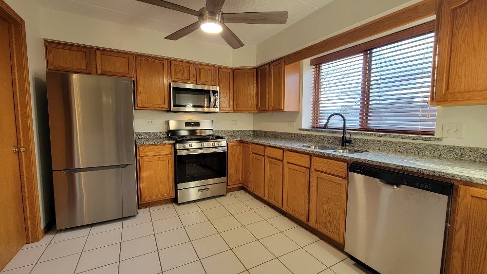 18100 Rita Road, Unit 2D Tinley Park, IL 60477 - Photo 8 of 28 a kitchen with stainless steel appliances granite countertop a refrigerator sink and microwave