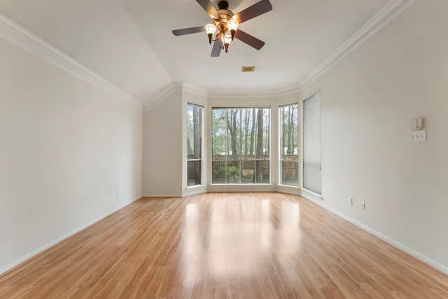 a view of room with window ceiling fan and hardwood floor