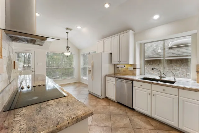 a large kitchen with kitchen island a sink stainless steel appliances and cabinets