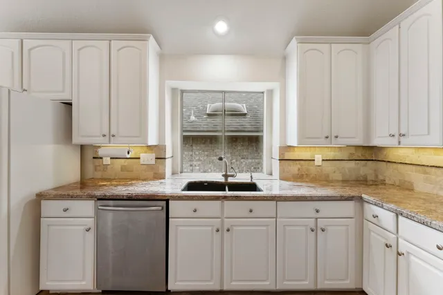 a kitchen with white cabinets and a sink