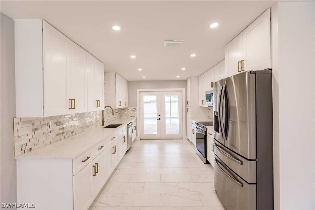 1623 Coronado Road Fort Myers, FL 33901 - Photo 3 of 24 a kitchen with stainless steel appliances a refrigerator sink and cabinets