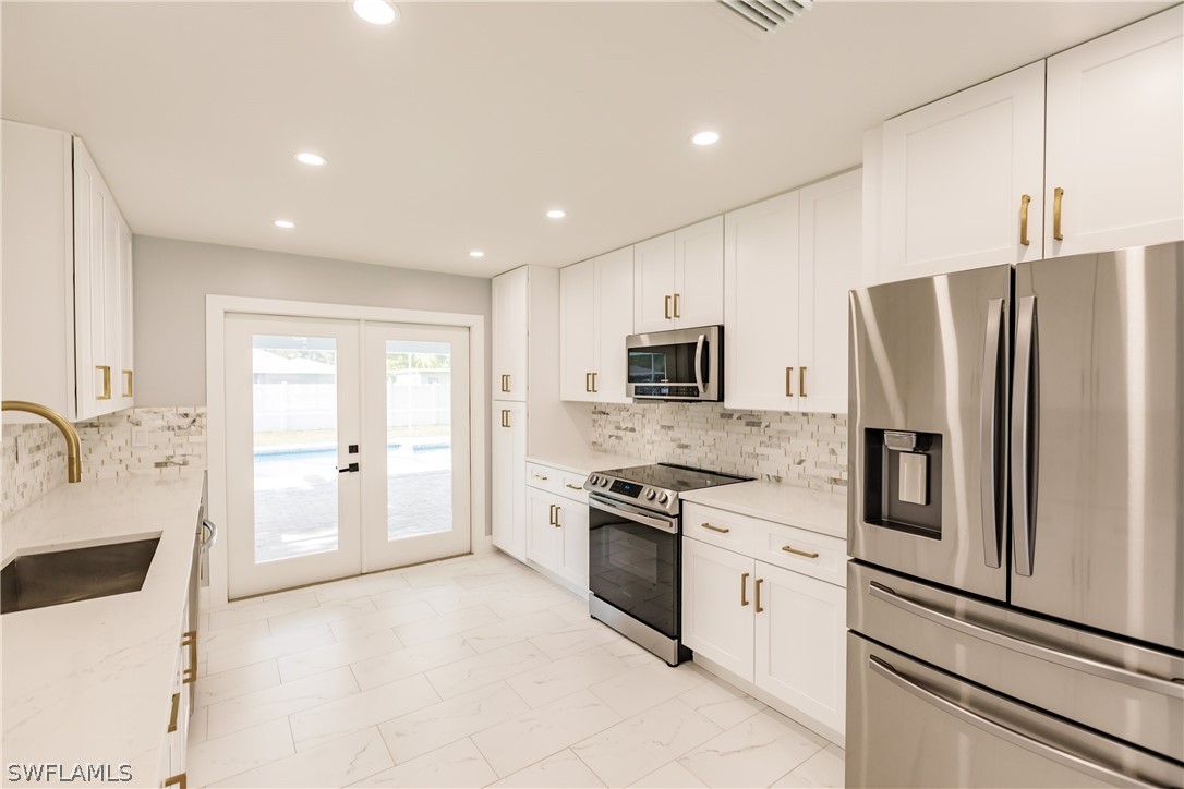 1623 Coronado Road Fort Myers, FL 33901 - Photo 4 of 24 a kitchen with stainless steel appliances a refrigerator stove and sink