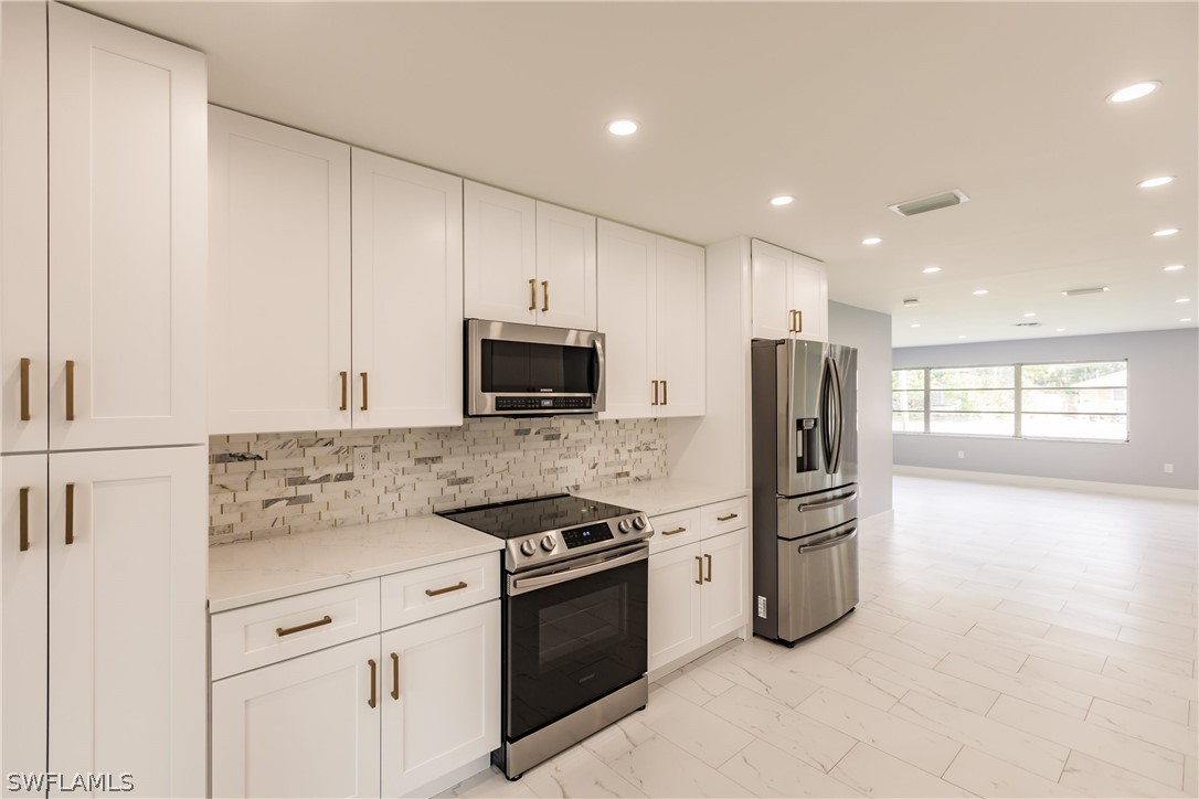 1623 Coronado Road Fort Myers, FL 33901 - Photo 6 of 24 a kitchen with stainless steel appliances granite countertop a refrigerator stove and microwave