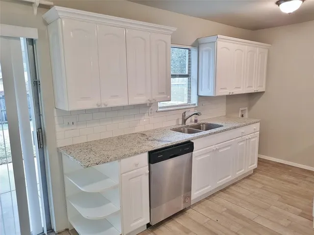 a kitchen with granite countertop white cabinets and sink