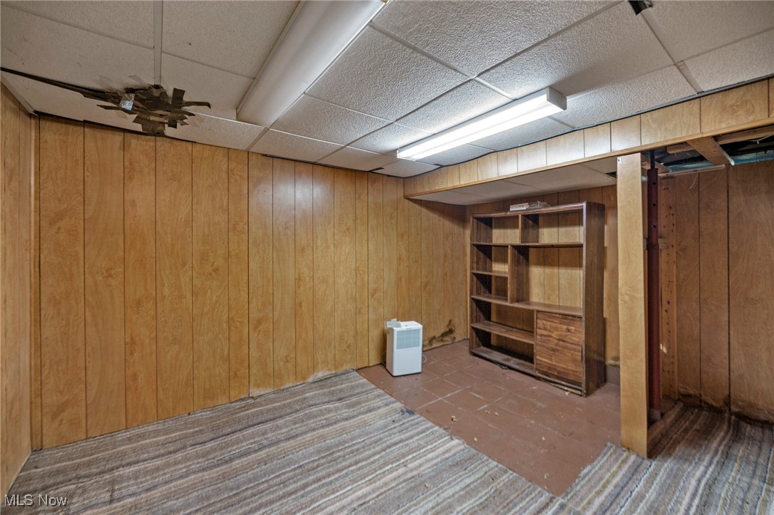 1589 Hampton Road Akron, OH 44305 - Photo 22 of 26 Finished basement featuring a drop ceiling, wooden walls, and carpet floors