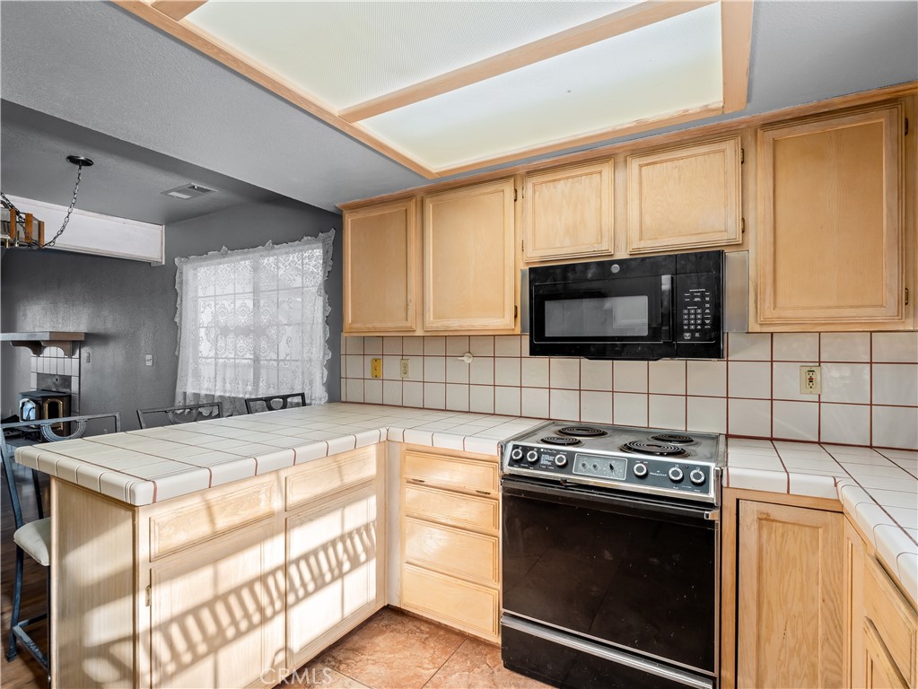 40557 Saddleback Road Bass Lake, CA 93604 - Photo 11 of 31 a kitchen with stainless steel appliances a stove microwave and sink