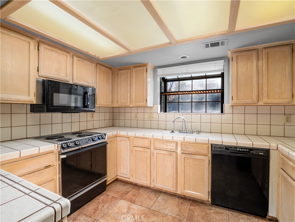 40557 Saddleback Road Bass Lake, CA 93604 - Photo 10 of 31 a kitchen with stainless steel appliances a stove sink microwave and cabinets
