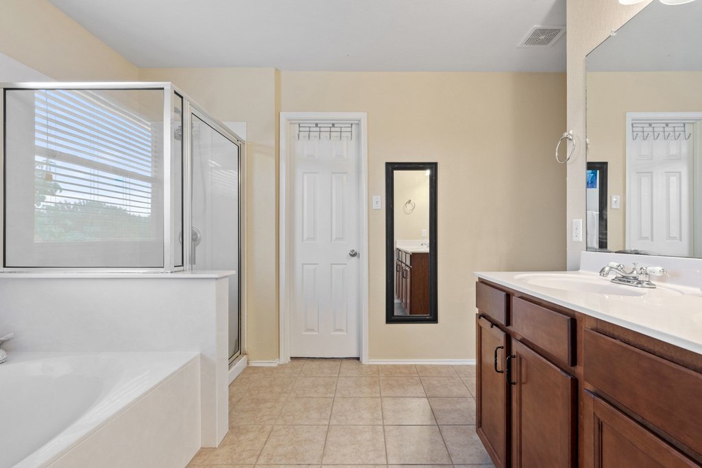 140 Wolfberry Path Buda, TX 78610 - Photo 24 of 35 a bathroom with a sink a bathtub and a mirror