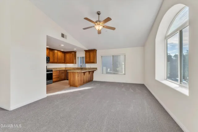 a view of a livingroom with a ceiling fan and window