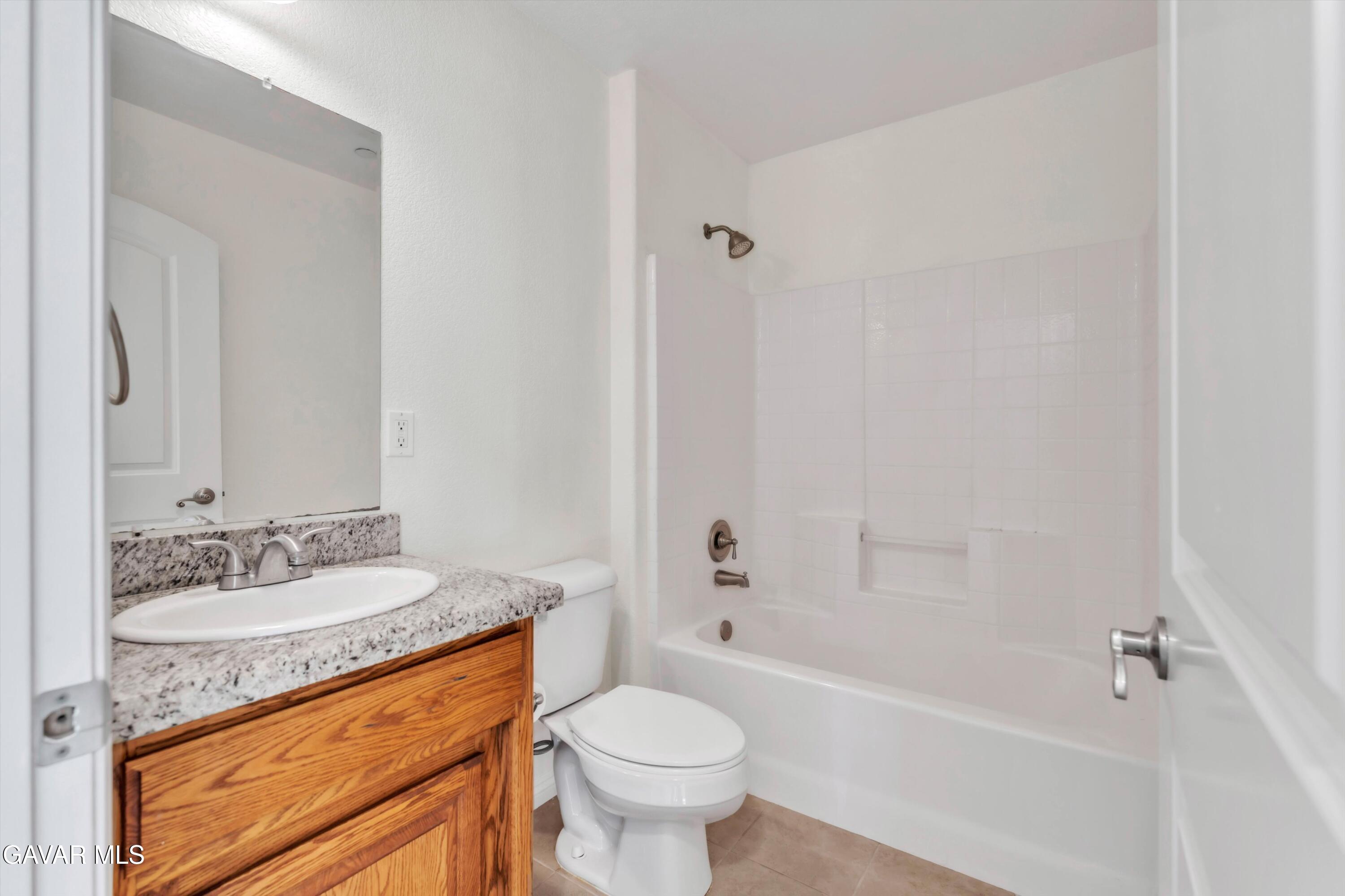 17819 Elizabeth Lake Road Lake Hughes, CA 93532 - Photo 22 of 28 a bathroom with a granite countertop toilet a sink and a bathtub